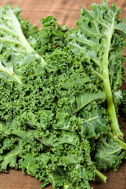 istock Curly kale leaves on wooden table 538570887