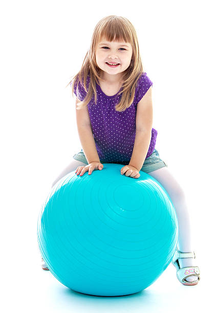 istock girl doing exercises on the big blue ball 538570953