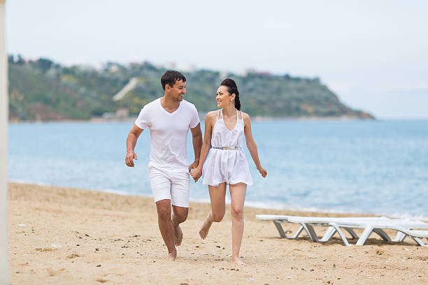 istock Barefoot couple on sand seashore in cloudy day 538571356