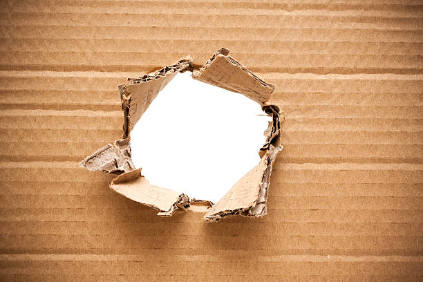 Ripped hole in cardboard background textured stock photo