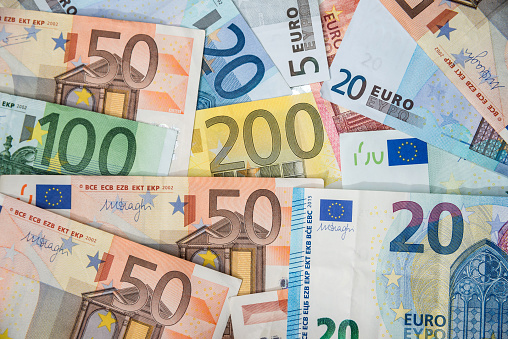 Euro banknotes of different denominations in the background