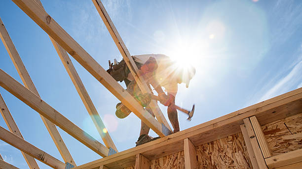 Construction Worker Framing A Building Construction worker framing a building against a sunny blue sky. cirrus photos stock pictures, royalty-free photos & images
