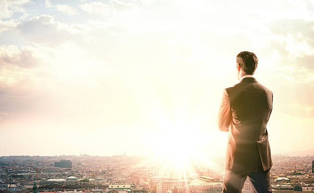 istock Young businessman standing on edge of rock 538575898