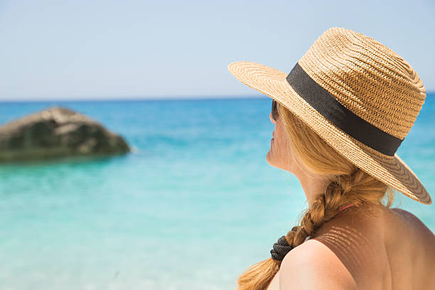 istock woman in summer hat on beach 538576586