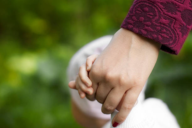 istock mother holds the child's hand 538583462