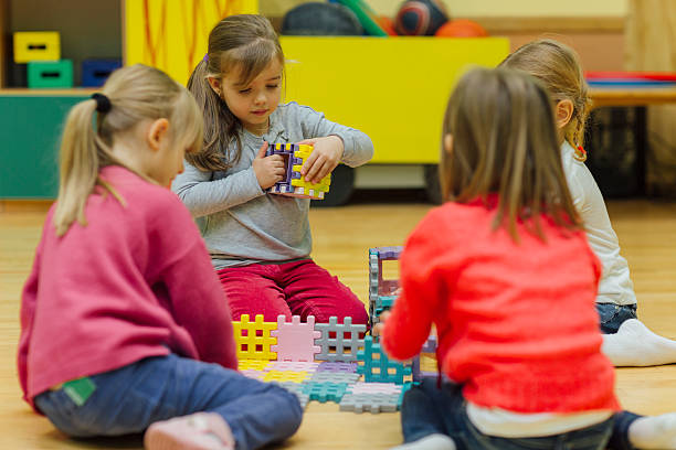istock Cute girls playing with blocks in kindergarten 538585242