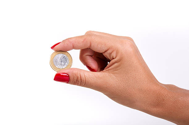 Woman's hand holding a Brazilian coin