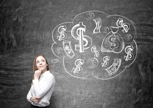Thoughtful businesswoman with money on her mind on chalkboard background