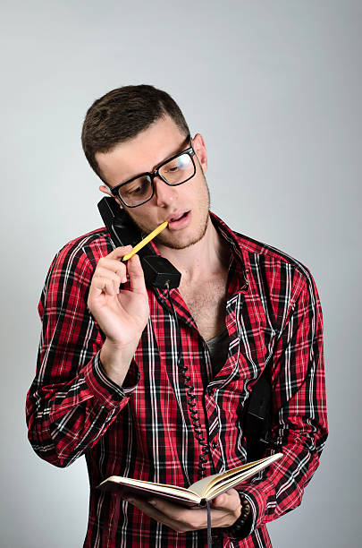 istock young man talking by telephone and writing in note 538595894
