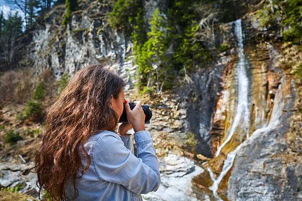 istock Woman taking photos of a waterfall 538597122