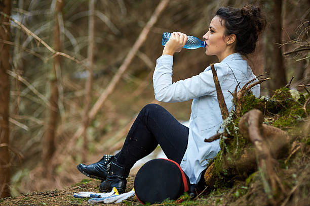 istock Woman trekker drinking water in the forest 538597474