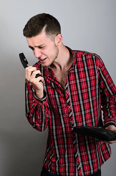 istock Angry businessman yelling into landline phone on grey 538599738