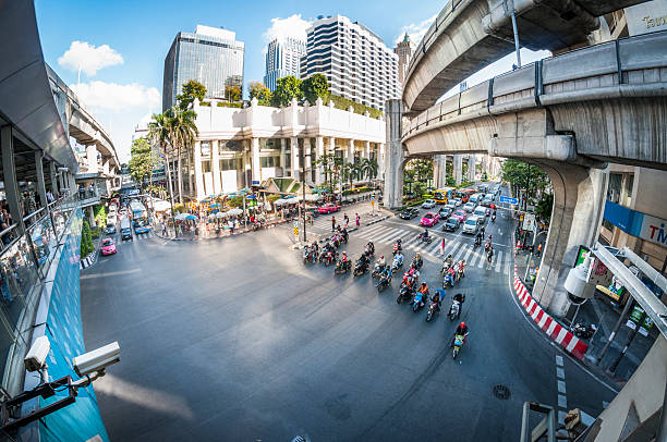 Bangkok, Thailand - November 1, 2013: Pedestrians and traffic in a busy street scene near Siam Square in Bangkok, Thailand. Showing Thao Mahaprom Shrine and the elevated train line.