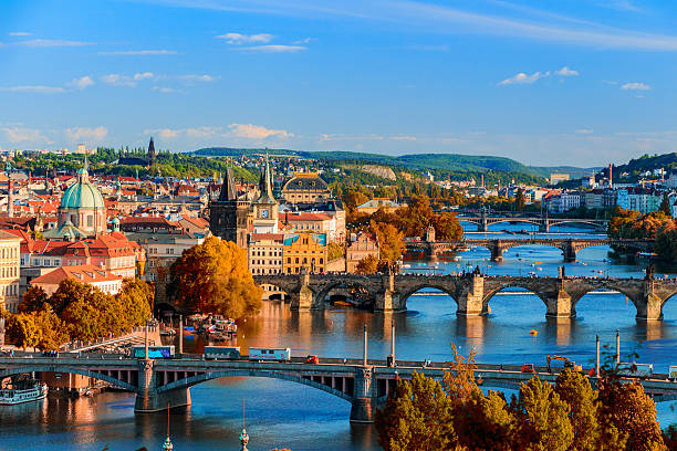 río vltava, cruce el puente charle con follaje rojo - architecture blue bohemia built structure fotografías e imágenes de stock