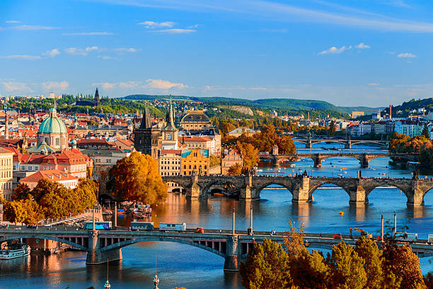 fiume moldava e ponte con fogliame rosso charle - architecture blue bohemia built structure foto e immagini stock