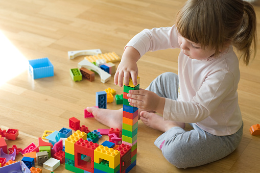 little girl playing with toy blocks
