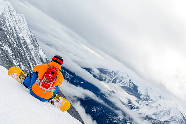 istock Backcountry snowboarder on Mountain Summit and looking at the cliff 538618157