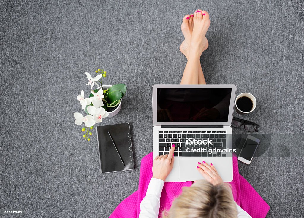 Woman working with computer in style Fashionable young woman working with computer, view from above. Flooring Stock Photo