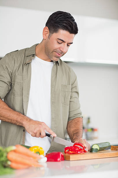 istock Smiling man chopping vegetables in the kitchen 538620221