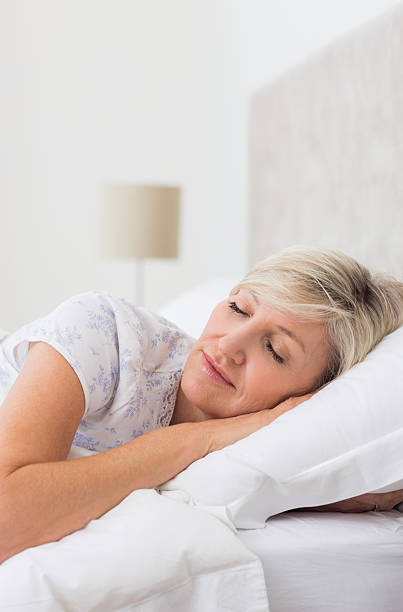 istock Mature woman sleeping with eyes closed in bed 538621895