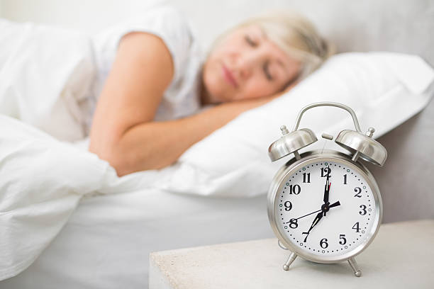 istock Woman sleeping in bed with alarm clock 538621923
