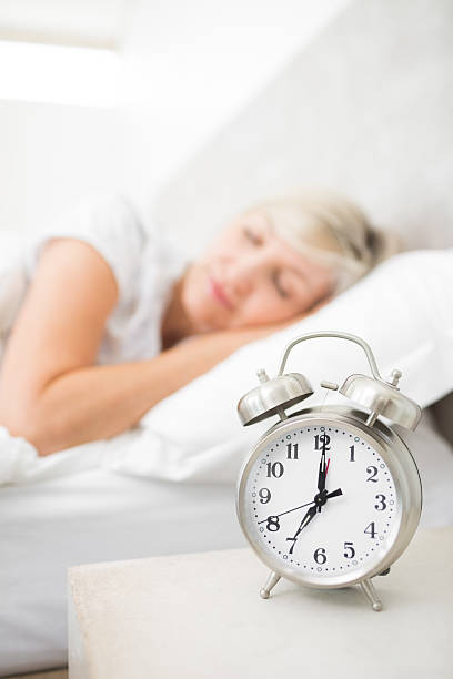 istock Woman sleeping in bed with alarm clock 538621925