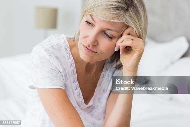 Tensed Reife Frau Sitzend Im Bett Stockfoto und mehr Bilder von Frauen - Frauen, Traurigkeit, Frauen über 40