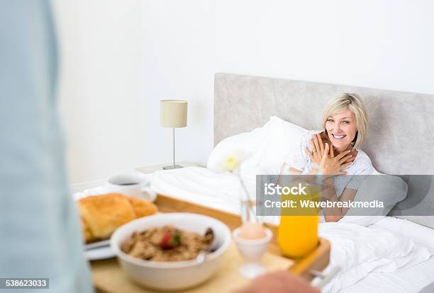 Happy Woman Sitting In Bed Stock Photo - Download Image Now - 2015, 50-54 Years, 50-59 Years