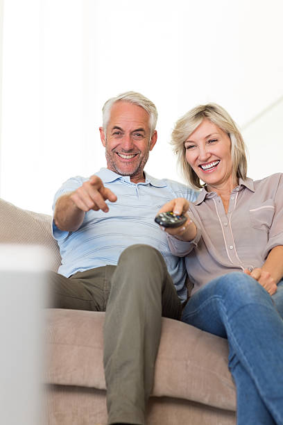 istock Happy couple watching tv on sofa 538623759