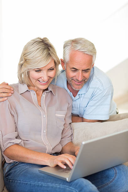 istock Happy mature couple using laptop on sofa 538624089