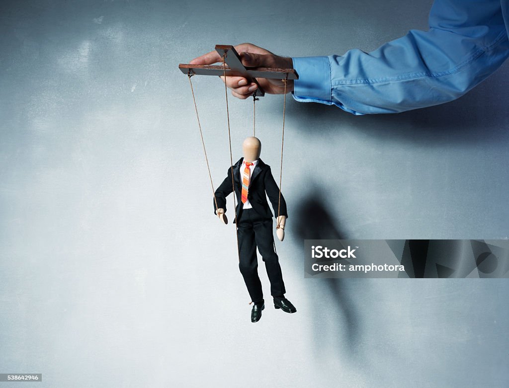 Business Marionettes Businessman's hand controlling a worker marionette. Puppet Stock Photo