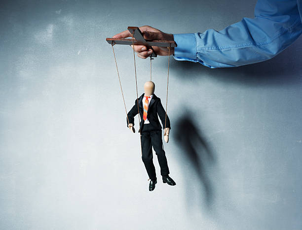 Business Marionettes Businessman's hand controlling a worker marionette. exploitation stock pictures, royalty-free photos & images