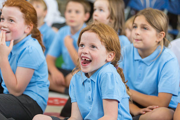 Young school girl in uniform paying attention in class