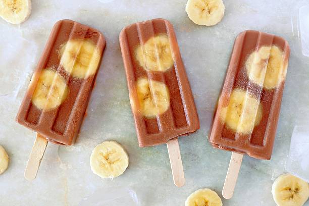istock Chocolate banana popsicles on white marble 538645240