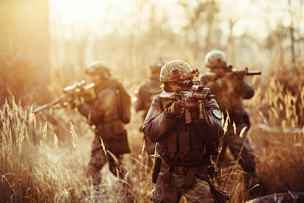 soldados con pistolas en el campo de - army men fotograf�ías e imágenes de stock