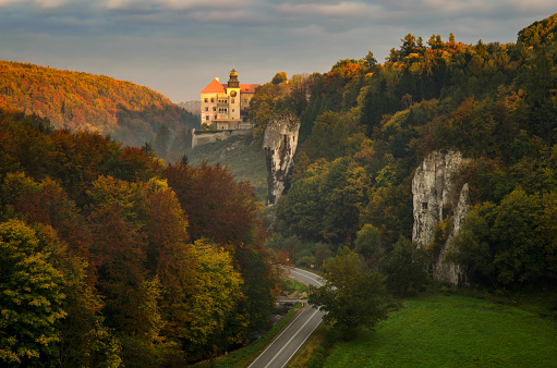 Sunrise at Pieskowa Skala Castle among autumn trees, Poland