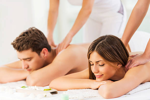 giovane coppia riceve massaggio alla schiena. - spa treatment health spa massaging couple foto e immagini stock