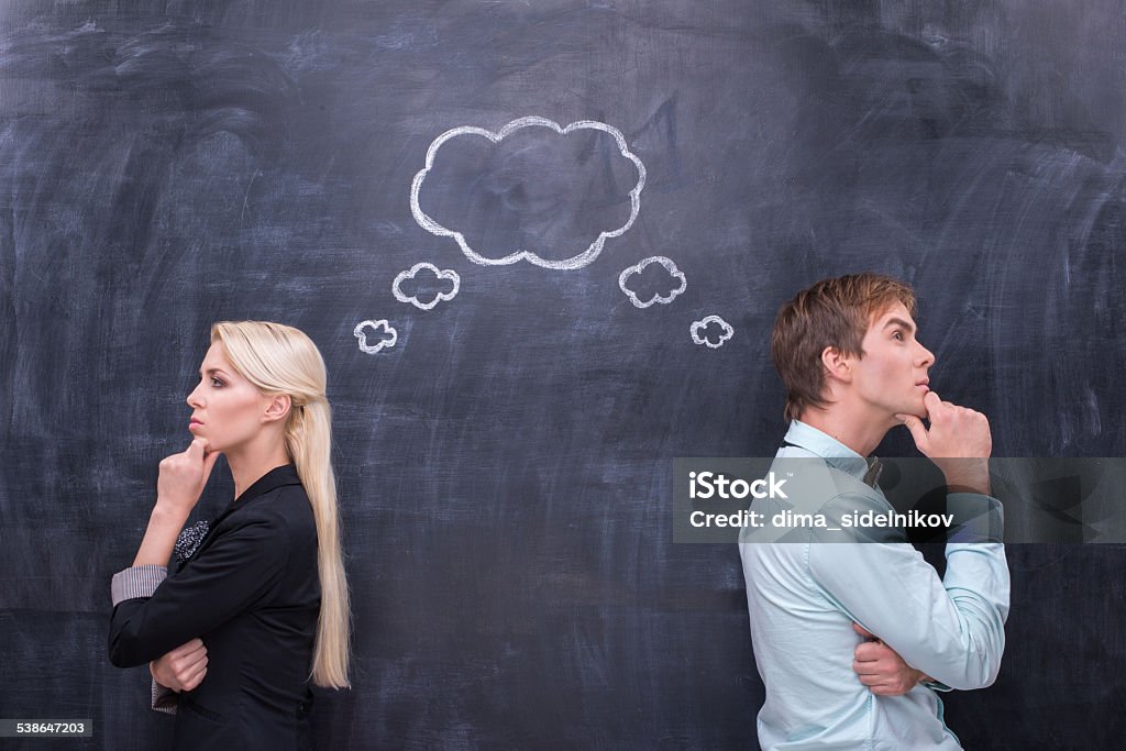 Bussinesman and bussineswoman searching the solution together Male and female thinking together on th blackboard background People Stock Photo
