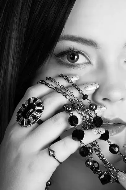 Photo of Vertical B&W closeup of young woman with black jewelry.