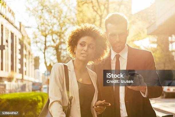Outdoor Portrait Of Two Business People With Smart Phones Stock Photo - Download Image Now