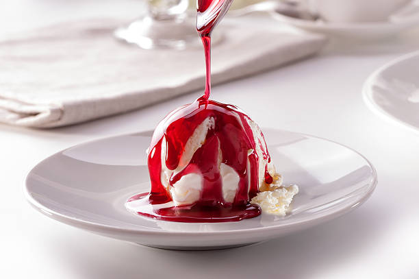 istock ice cream scoop with  pouring berry sauce from spoon close-up 538649328