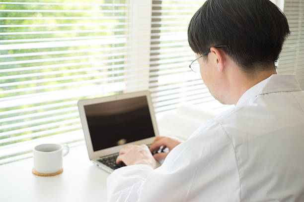 istock Man of a white robe doing desk work by window 538649776