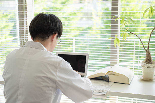 istock Man of a white robe doing desk work by window 538649992