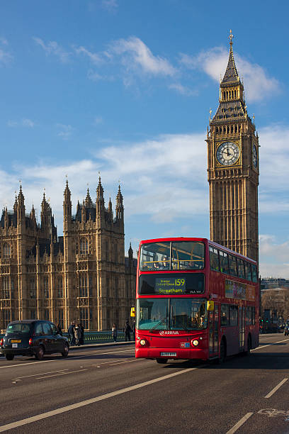 London, UK - January 30, 2015: Double Decker Bus, most iconic symbol of London, and Big Ben in far behind on Jan 30, 2015 in London, UK.
