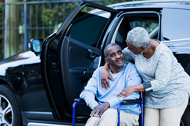 senior hombre discapacitado en silla de ruedas con su esposa dedicado - couple dependency standing men fotografías e imágenes de stock