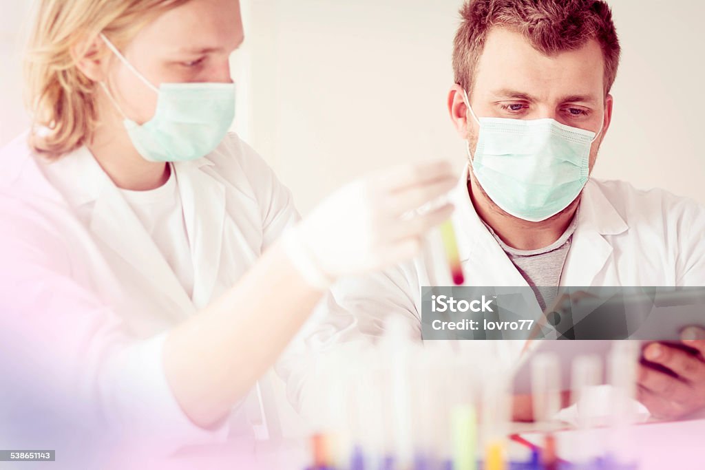 Scientist holding a tube test with chemical mixture Scientist and his assistant checked the chemical mixture in tube test.  2015 Stock Photo