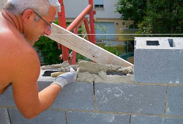 mason realiza un diseño de bloques de cemento externo - mason brick bricklayer installing fotografías e imágenes de stock