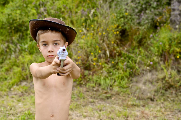 istock young kid with gun takes aim front to the camera 538651331