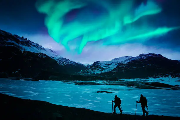 Hikers under the northern lights in Iceland.