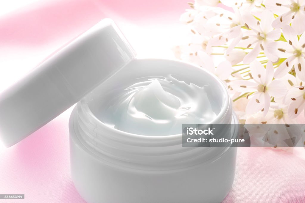 Beauty cream on the pink cloth Beauty cream and white flowers on pink cloth Adult Stock Photo